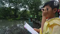 Seorang anak memantau aktivitas burung pada kegiatan Asian Waterbird Census 2019 di Hutan Lindung Angke Kapuk Jakarta, Sabtu (19/1). Kegiatan yang diinisiasi Yayasan KEHATI ini bertujuan memperkenalkan keanekaragaman hayati. (Liputan6.com/Fery Pradolo)