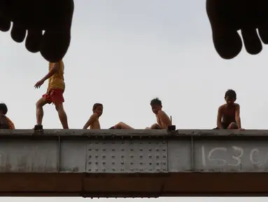 Anak-anak bersiap melompat ke Sungai Ciliwung yang meluap di kawasan Rawajati, Jakarta, Jumat (26/4). Tingginya volume debit air yang berasal dari Bogor tidak menyurutkan niat anak-anak itu untuk tetap berenang, meskipun berbahaya bagi keselamatan. (Liputan6.com/Immanuel Antonius)