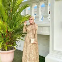 Kamu juga bisa pakai gamis brokat warna cokelat keemasan seperti ini. Tambahkan belt untuk membuat kesan tubuh yang lebih ramping. (Instagram/yollaanggitaaa).
