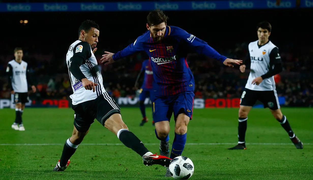 Pemain Barcelona, Lionel Messi berebut bola dengan pemain Valencia, Francis Coquelin pada semifinal pertama Copa del Rey di Stadion Camp Nou, Jumat (2/2). Barcelona menang 1-0 berkat gol semata wayang Luis Suarez. (AP/Manu Fernandez)