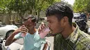 <p>Para komuter meminum air manis yang dibagikan pada hari yang panas di New Delhi, India, Sabtu, 14 Mei 2022. Suhu di New Delhi mencapai 45 Derajat Celcius. (AP Photo/Manish Swarup)</p>