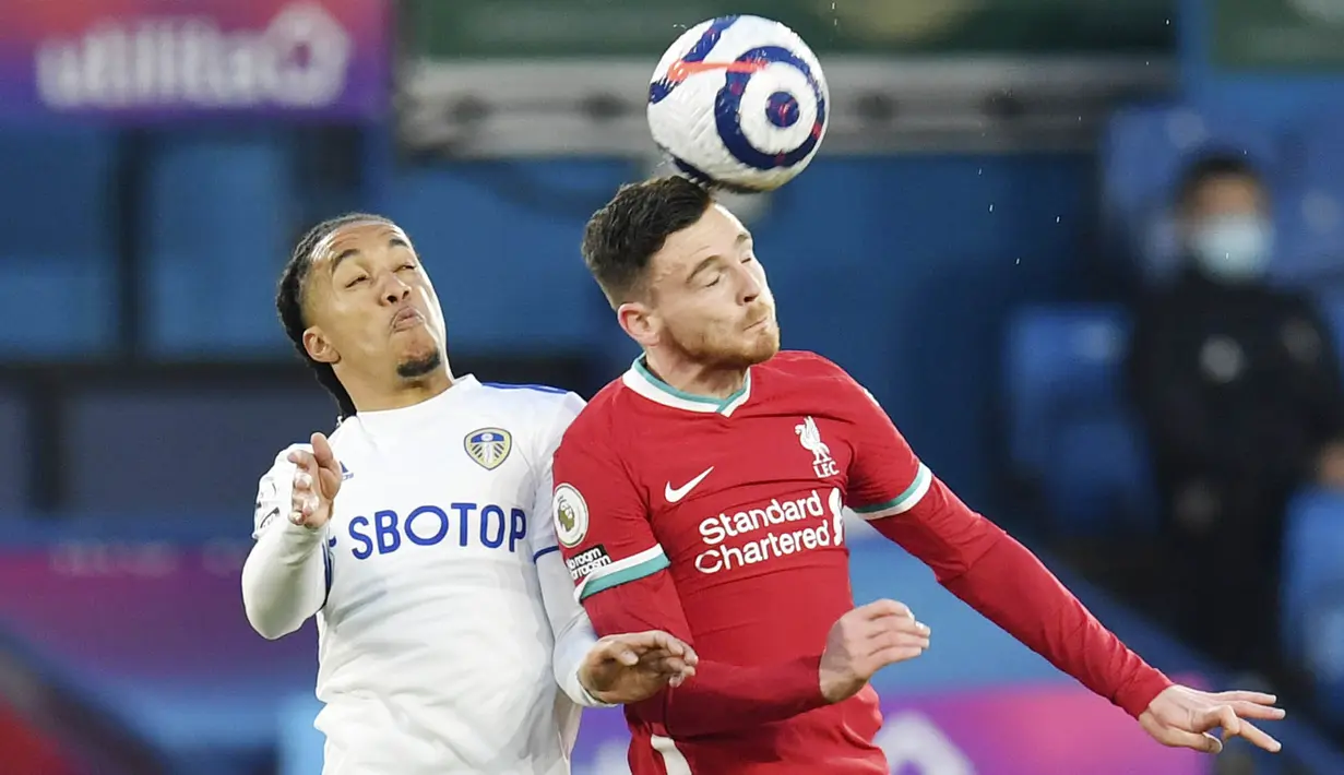 Bek Liverpool, Andrew Robertson, duel udara dengan pemain Leeds United, Helder Costa, pada laga Liga Inggris di Stadion Elland Road, Senin (19/4/2021). Kedua tim bermain imbang 1-1. (Paul Ellis/Pool via AP)