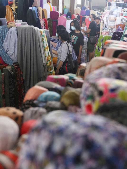 Calon pembeli memilih kain di Pasar Cipadu, Tangerang, Selasa (2/3/2021). Pandemi Covid-19 membuat industri tekstil dan pakaian jadi mengalami pertumbuhan negatif 8, 8% sepanjang 2020, bahkan pandemi membuat tenaga kerja di sektor industri tekstil berkurang hingga 13%. (Liputan6.com/Angga Yuniar)