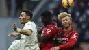 Bek AC Milan, Simon Kjaer dan gelandang Tiemoue Bakayoko berebut bola udara dengan pemain Sassuolo, Kaan Ayhan pada pertandingan lanjutan Liga Serie A Italia di stadion San Siro, Minggu (28/11/2021). AC Milan kalah atas Sassuolo 1-3. (Spada/LaPresse via AP)