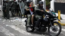 Seorang demonstran dibawa petugas saat bentrok di San Cristobal, Venezuela (26/10). Unjuk rasa bertajuk "Ambil Alih Venezuela" ini menuntut adanya referendum untuk melengserkan Maduro. (REUTERS/Carlos Eduardo Ramirez)