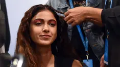 Seorang model saat ditata rambutnya oleh kru makeup di belakang panggung sebelum tampil di catwalk selama Lakmé Fashion Week (LFW) Summer Resort 2019 di Mumbai, India (31/1). (AFP Photo/Sujit Jaiswal)