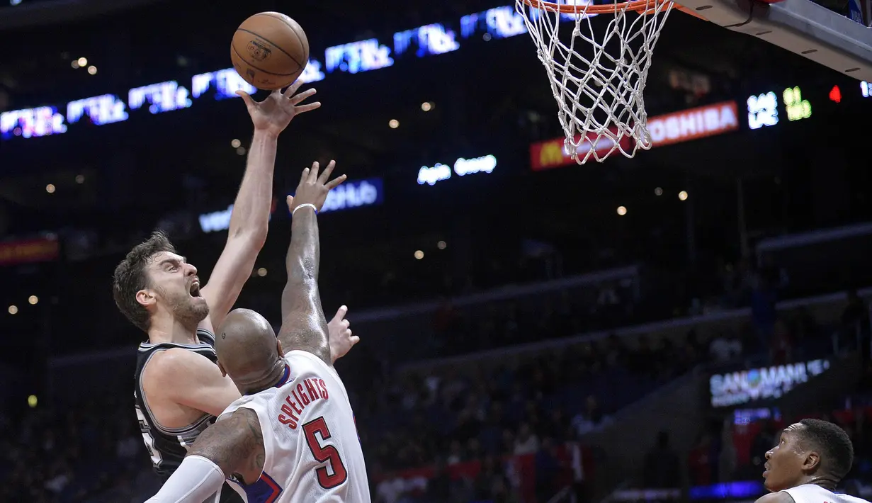 Ekspresi pemain Spurs, Pau Gasol (kiri) saat melakukan tembakan melewati hadangan pemain L. A. Clippers, Marreese Speights pada laga NBA basketball game di Staples Center, (22/12/2016). Clippers menang 106-101. (Reuters/Gary A. Vasquez-USA TODAY Sports)