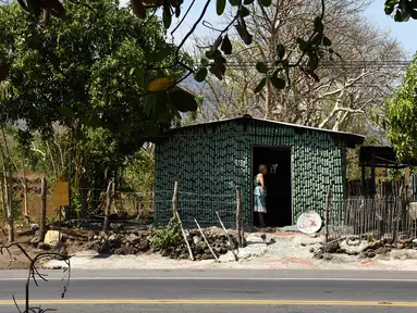 Nenek berusia 86 tahun, Maria Ponce berdiri di pintu rumahnya yang terbuat dari botol plastik bekas di Desa El Borbollon, El Transito, San Salvador, El Salvador 14 Maret 2017. Nenek ini membangun rumah pada 12 tahun silam. (AFP Photo/Marvin Recinos) 