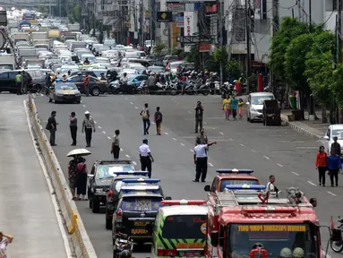 Kendaraan petugas menutup dan mengalihkan arus lalu lintas sebagian ruas jalan Gajah Mada, Jakarta, Senin (2/1). Pengalihan akibat kebakaran yang terjadi di Grand Hotel Paragon. (Liputan6.com/Helmi Fithriansyah)