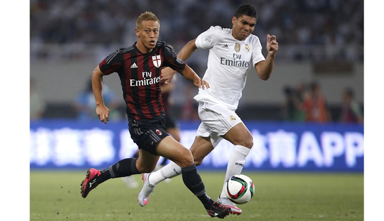 Pemain AC Milan Keisuke Honda menggiring bola melewati hadangan pemain Real Madrid, Casemiro pada laga International Champions Cup 2015 di Shanghai, China, Kamis (30/7). (Reuters Aly Song)