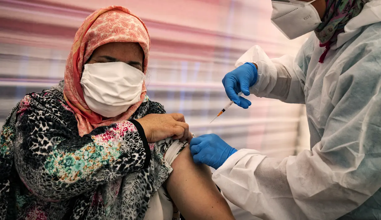 Seorang tahanan perempuan menerima suntikan vaksin Covid-19 AstraZeneca selama kampanye vaksinasi di penjara El-Arjate dekat ibu kota Rabat pada 26 Mei 2021. Setidaknya 12.000 dari 85.000 tahanan di Maroko telah divaksinasi sejak kampanye nasional dimulai pada Januari lalu. (FADEL SENNA/AFP)