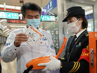 Seorang staf dari Pusat Medis Darurat Beijing mendemonstrasikan penggunaan automated external defibrillator (AED) kepada petugas kereta bawah tanah di Beijing, China, 27 Oktober 2020. Beijing pada Selasa (27/10) mulai melengkapi sistem transportasi berbasis relnya dengan AED. (Xinhua/Zhang Chenlin)