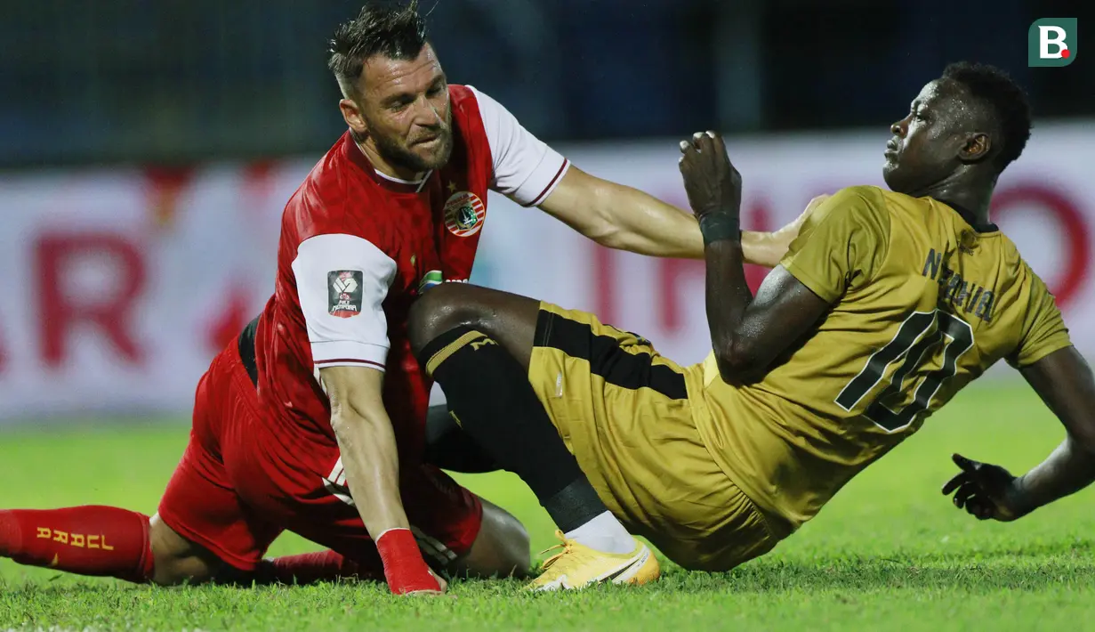Striker Persija Jakarta, Marko Simic (kiri) saling dorong dengan striker Bhayangkara Solo FC, Ezechiel N'Douassel, pada laga Piala Menpora 2021 di Stadion Kanjuruhan, Malang, Rabu (31/3/2021). Persija Menang dengan skor 2-1. (Bola.com/M Iqbal Ichsan)