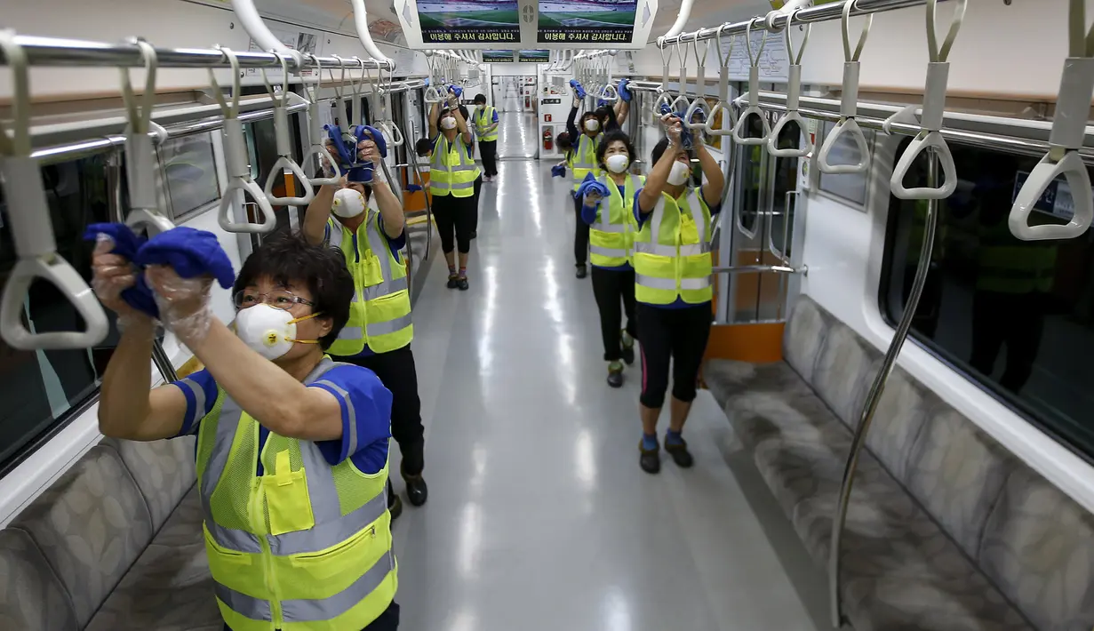 Sejumlah petugas membersihkan pegangan di dalam kereta guna mencegah penyebaran wabah virus MERS di stasiun Seoul Metro, Goyang, Korsel, (9/6/2015). Sekitar 95 orang terjangkit wabah virus MERS dan 7 orang meninggal dunia di Korsel. (REUTERS/Kim Hong-Ji)