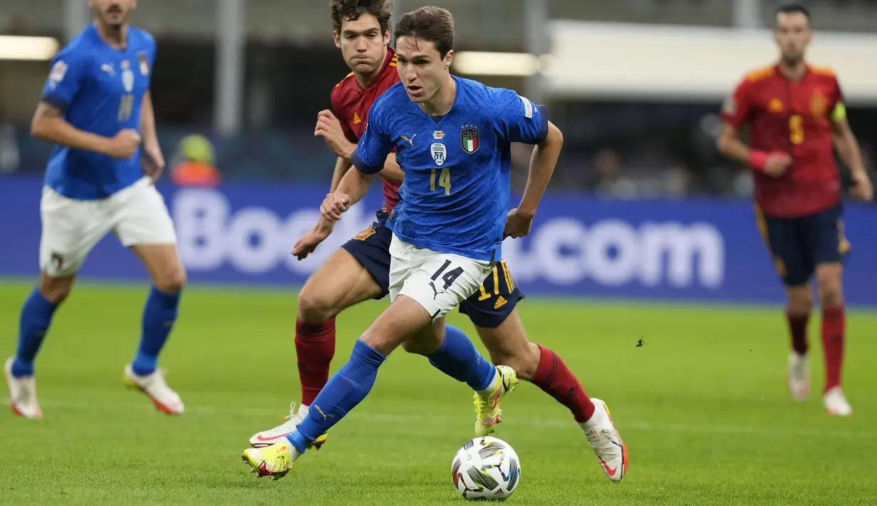 Penyerang Italia, Federico Chiesa membawa bola dari kejaran bek Spanyol, Marcos Alonso pada semifinal UEFA Nations League di stadion San Siro, Milan, (7/10/2021). Berkat hasil ini, Spanyol berhak melaju ke partai final untuk menghadapi pemenang Belgia dengan Spanyol. (AP Photo/Antonio Calanni)