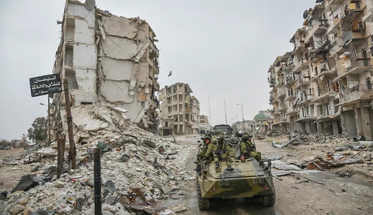 Tentara Rusia berada di kendaraan militer saat melakukan patroli dalam operasi APCs di Aleppo, Suriah. (Russian Defense Ministry Press Service photo via AP)