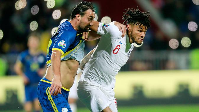 Bek timnas Inggris, Tyrone Mings, berebut bola dengan pemain Timnas Kosovo, Atdhe Nuhiu pada laga Grup A kualifikasi Piala Eropa 2020 di Fadil Vokrri Stadium, Minggu (17/11/2019). Timnas Inggris mampu meraih kemenangan telak 4-0 atas timnas Kosovo. (AP/Visar Kryeziu)