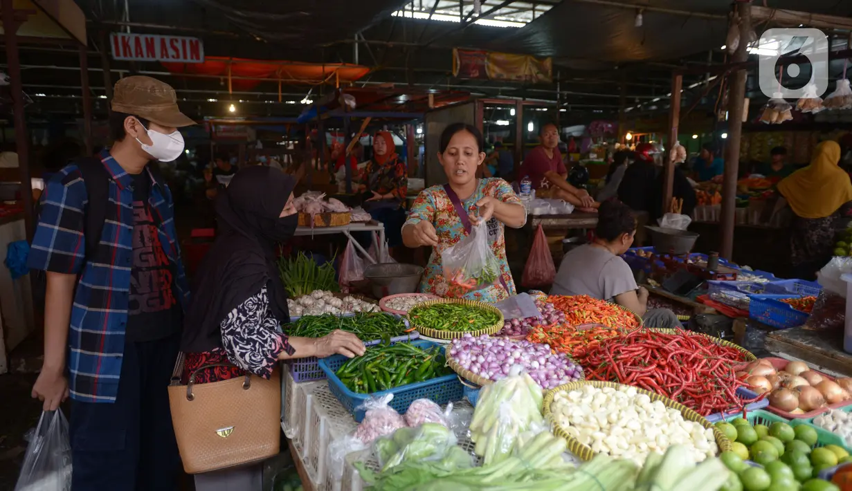 Pedagang  melayani pembeli di pasar tradisoonal Kebayoran, Jakarta, Rabu (3/11/2021). Meskipun pemerintah sudah menurunkan level 1 masa PPKM berskala mikro pedagang mengatakan masih resah karena menurunnya pendapatan harian ditambah sejumlah bahan pokok mengalami kenaikan. (merdeka.com/Imam Buhori)