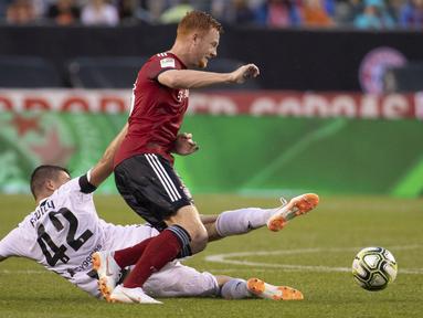 Pemain FC Bayern, Paul Will (kanan) mencoba melewati adangan pemain Juventus, Andrea Favilli pada laga International Champions Cup 2018 di Lincoln Financial Field, Philadelphia, (25/7/2018). Juventus menang 2-0.  (AP/Chris Szagola)