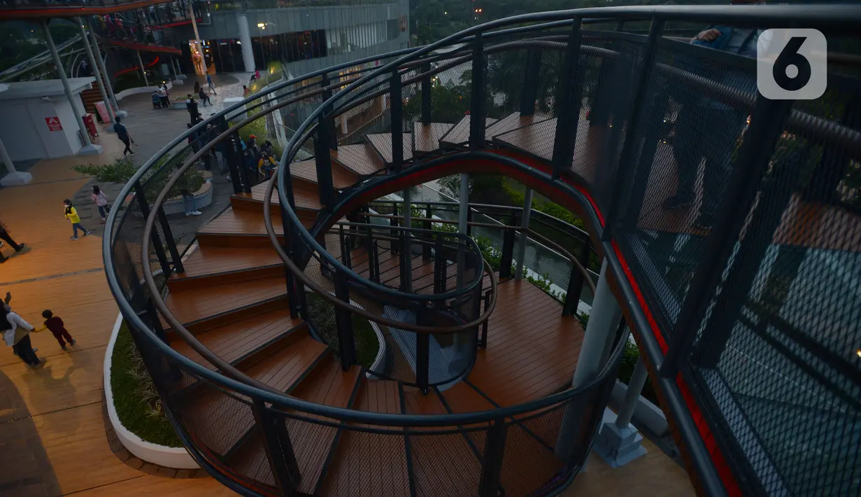 Pengunjung menikmati suasana di Skywalk Senayan Park, Jakarta, Rabu (29/12/2021). Kawasan yang menyajikan pemandangan lanskap perkotaan itu menjadi alternatif destinasi wisata Jakarta yang instagramble dengan spot foto yang beragam. (merdeka.com/Imam Buhori)