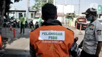 Seorang warga mengenakan rompi pelanggar PSBB akibat tidak mengenakan masker di area Pasar Kramat Jati, Jakarta, Rabu (17/6/2020). (merdeka.com/Iqbal S. Nugroho)