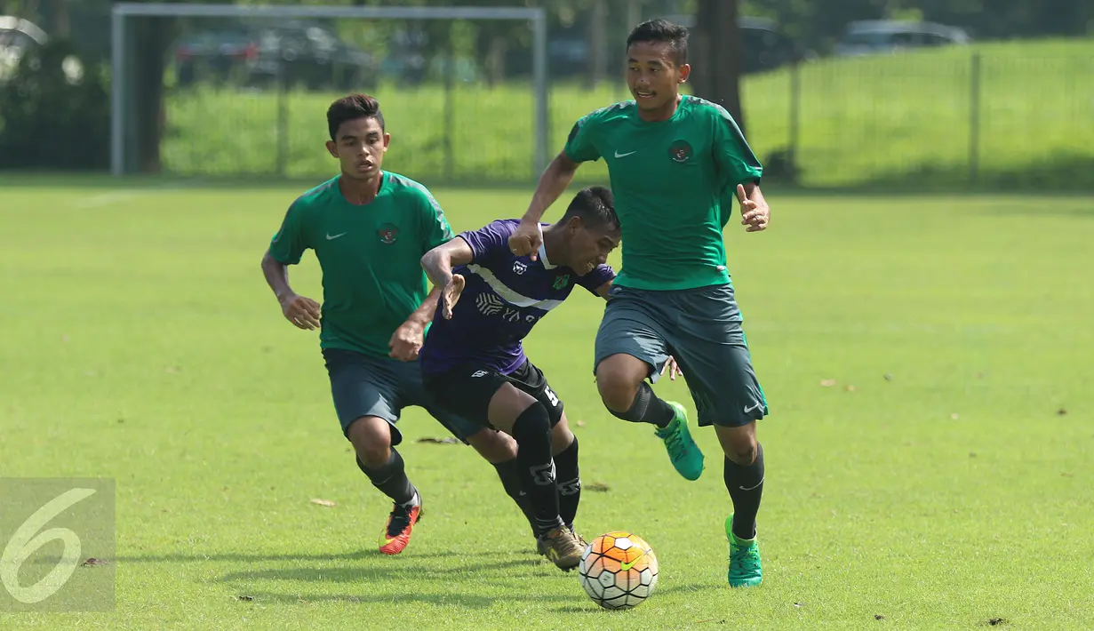 Dua pemain Timnas Indonesia U-22 berusaha menahan laju pemain Persita saat laga uji coba di Lapangan SPH Karawaci, Tangerang, Selasa (25/4). Timnas Indonesia U-22 unggul 2-1. (Liputan6.com/Helmi Fithriansyah)