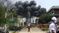 Asap hitam terlihat membumbung di lokasi kebakaran gardu induk PLN di Kembangan, Jakarta Barat, Rabu (2/9/2015). Akibat kebakaran ini, PLN terpaksa memadamkan jaringan listrik di sejumlah titik di Jakarta dan Tangerang. (Liputan6.com/Gempur M Surya)