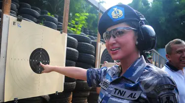 Dewi Perssik menunjuk titik sasaran seusai lomba menembak bersama KSAL Laksamana TNI Ade Supandi, di Lapangan Tembak Mabesal, Cilangkap, Jakarta, Jumat (27/2/2015). (Liputan6.com/Yoppy Renato)