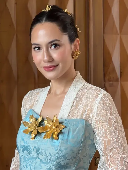 Pevita Pearce tampil memesona mengenakan atasan kebaya brokat putih lengan panjang sebagai inner dipadukan buister warna biru yang dihiasi bros besar serasi dengan anting-anting dan hiasan rambutnya. [ @pevpearce]
