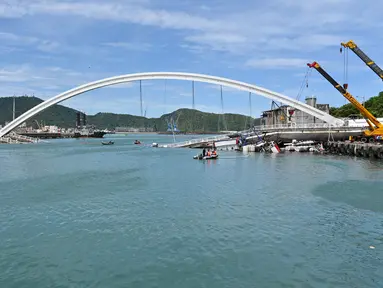 Sebuah jembatan  yang ambruk di pelabuhan ikan Nanfangao di kota Suao (1/10/2019). Jembatan beton yang ambruk tersebut menimpa beberapa perahu nelayan yang bersandar di bawahnya. (AFP Photo/Sam Yeh)