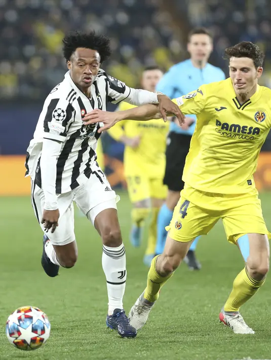 Gelandang Juventus, Juan Cuadrado berebut bola dengan pemain Villarreal, Pau Torres pada pertandingan leg pertama Liga Champions di Estadio de la Ceramica, Spanyol, Rabu (23/2/2022).  Juventus bermain imbang atas Villarreal 1-1.  (AP Photo/Alberto Saiz)