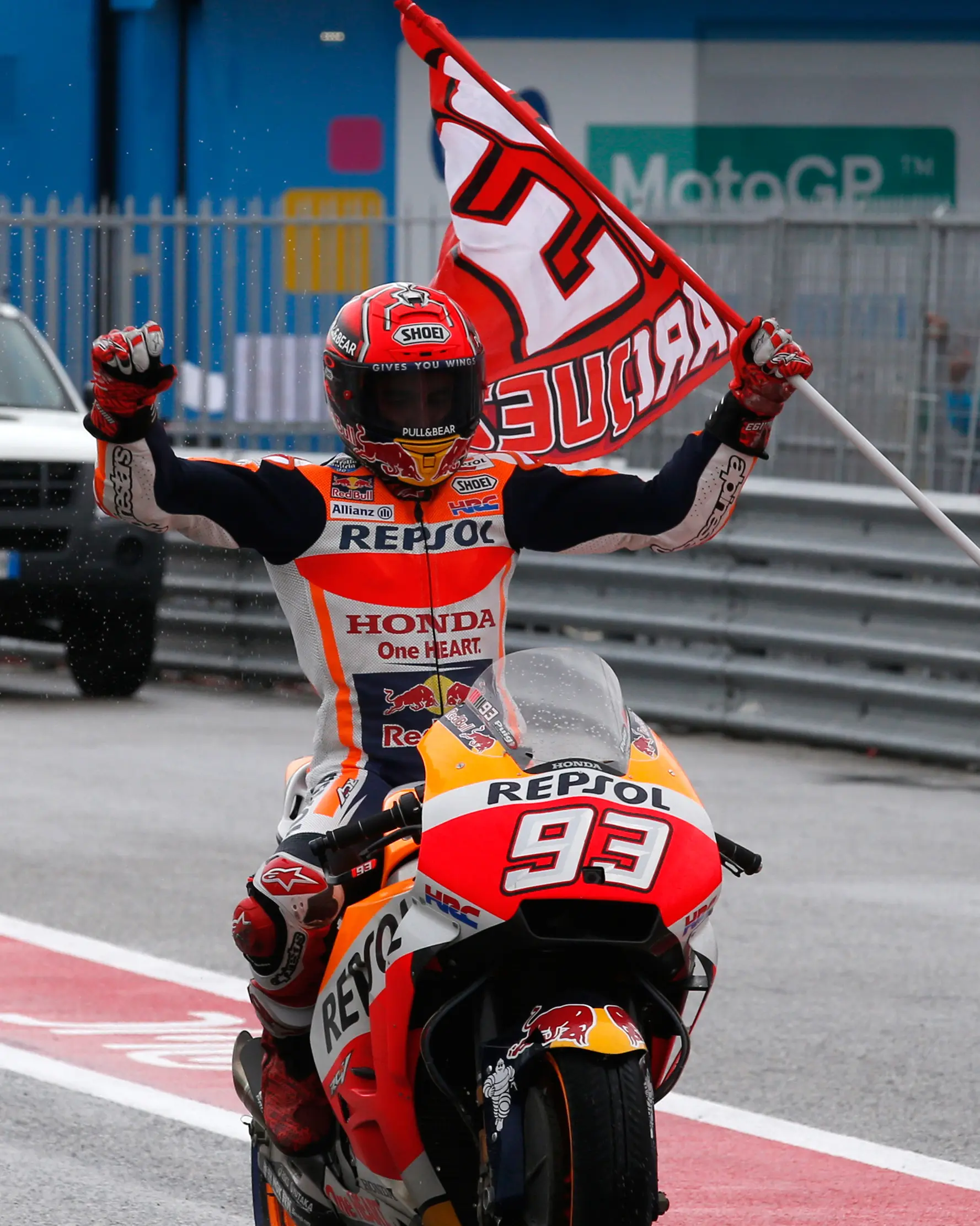 Pembalap Repsol Honda, Marc Marquez memegang bendera setelah keluar sebagai yang tercepat pada balapan MotoGP San Marino 2017 di Sirkuit Misano, Italia, Minggu (10/9). Bagi Marquez, ini merupakan kemenangan keempatnya musim ini. (AP Photo/Antonio Calanni)