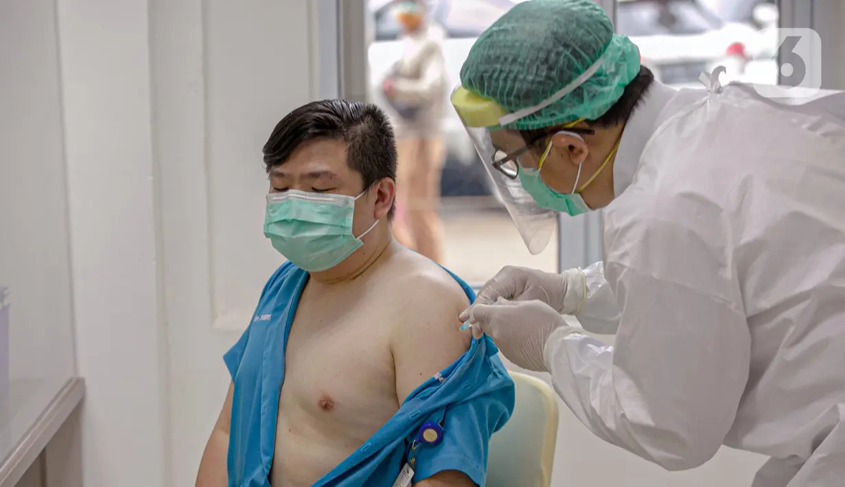 Tenaga kesehatan menjalani vaksinasi virus corona COVID-19 di RSCM, Jakarta, Kamis (14/1/2021). Vaksinasi COVID-19 tahap awal akan menargetkan 1,48 juta tenaga kesehatan. (Liputan6.com/Faizal Fanani)