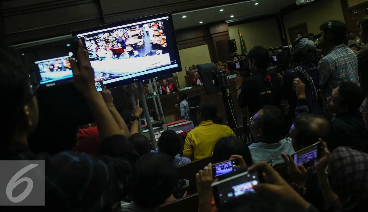 Sejumlah pengunjung sidang mengabadikan rekaman CCTV dalam persidangan saksi kasus pembunuhan Wayan Mirna Salihin di PN Jakarta Pusat, Rabu (13/7). Sidang menampilkan video CCTV yang berisi rekaman kejadian di Kafe Olivier. (Liputan6.com/Faizal Fanani)