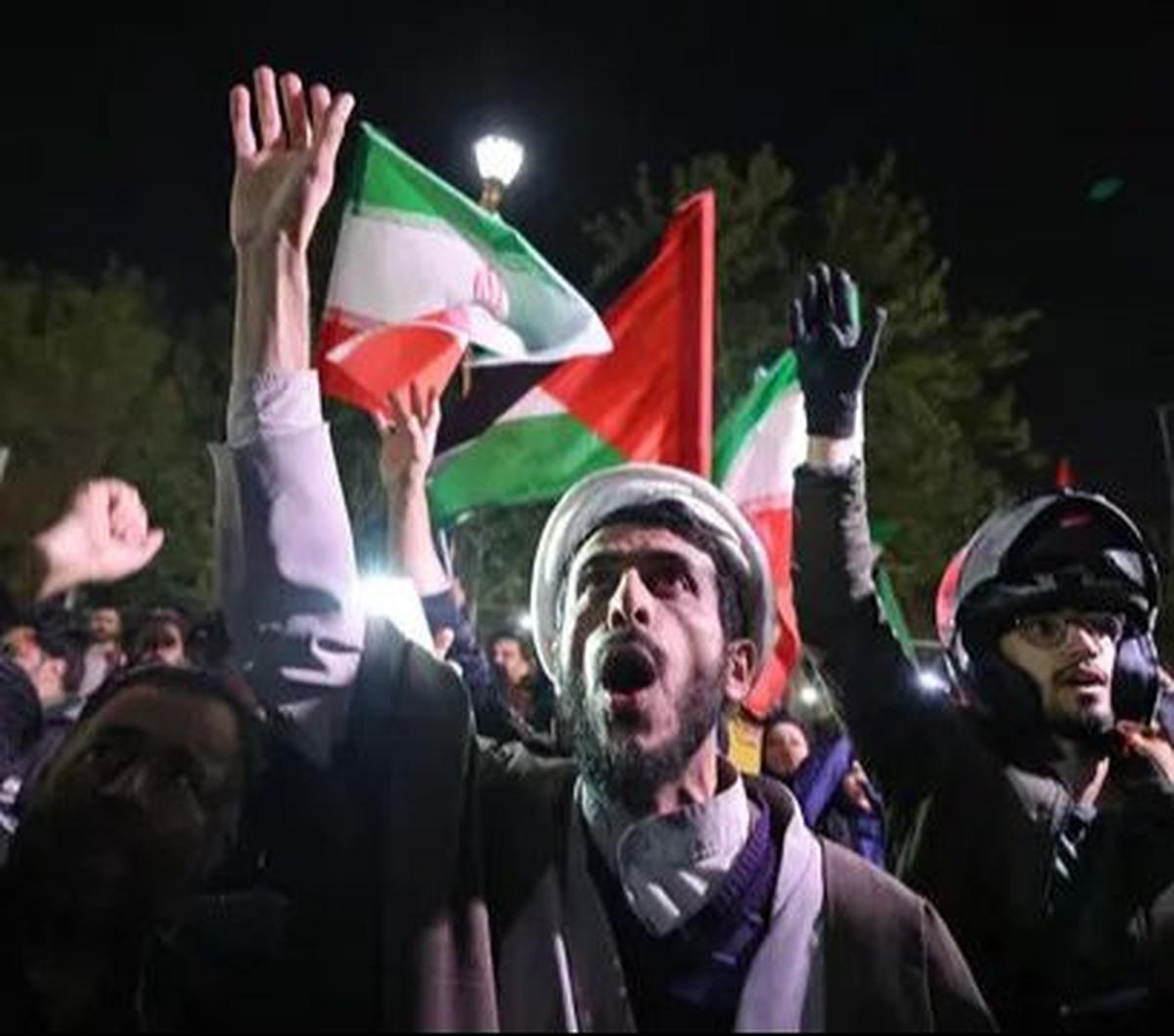Sejumlah pengunjuk rasa turun ke jalan dengan mengibarkan bendera kenegaraan di depan Kedutaan Besar Inggris, Teheran, Iran, Minggu (14/4/2024). Dalam aksinya, mereka menyuarakan dukungan atas serangan ratusan drone dan rudal yang ditembakkan Iran terhada