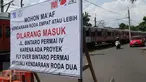 Sebuah papan pengumuman terpasang di dekat perlintasan kereta api Bintaro, Jakarta, Minggu (19/3). Rencana penutupan perlintasan rel kereta Bintaro ini per 1 April arus lalu lintas akan di alihkan ke jalan alternatif lainnya. (Liputan6.com/Helmi Afandi)