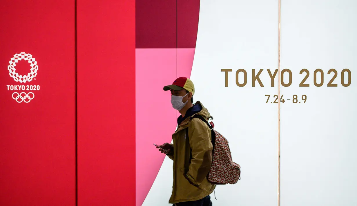 Seorang pria mengenakan masker pelindung berjalan di terowongan sebuah stasiun metro di Tokyo, Jepang, 11 Maret 2020. Pandemi virus corona COVID-19 membuat Jepang dilema untuk tetap menggelar Olimpiade 2020. (Photo by Philip FONG/AFP)