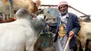 Seorang lelaki Yaman berdiri di antara kawanan sapi di pasar ternak menjelang Idul Adha di ibu kota Sanaa, 6 Agustus 2019. Umat Islam di seluruh dunia akan merayakan Idul Adha yang identik dengan tradisi berkurban menggunakan hewan seperti kambing, domba, unta, sapi dan kerbau. (MOHAMMED HUWAIS/AFP)