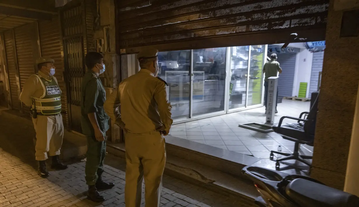 Pasukan keamanan Maroko memastikan penutupan toko dan meminta orang untuk kembali ke rumah di ibu kota Rabat pada Rabu (3/8/2021). Maroko memperpanjang jam malam dan memperketat pembatasan perjalanan ke tiga kota besar dalam upaya memperlambat lonjakan kasus corona COVID-19. (FADEL SENNA / AFP)