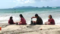 Anak-anak asyik bermain pasir pantai di Pantai Setigi Heni di Lampung Selatan saat liburan akhir tahun (Liputan6.com / Nefri Inge)