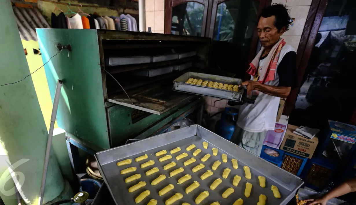 Pengrajin memasukan kue kering Lebaran ke dalam oven, di Kawasan Kwitang, Jakarta, Senin (29/6). Meskipun Lebaran masih beberapa pekan kedepan, produksi kue kering di sentra tersebut meningkat dua kali lipat. (Liputan6.com/Faizal Fanani)