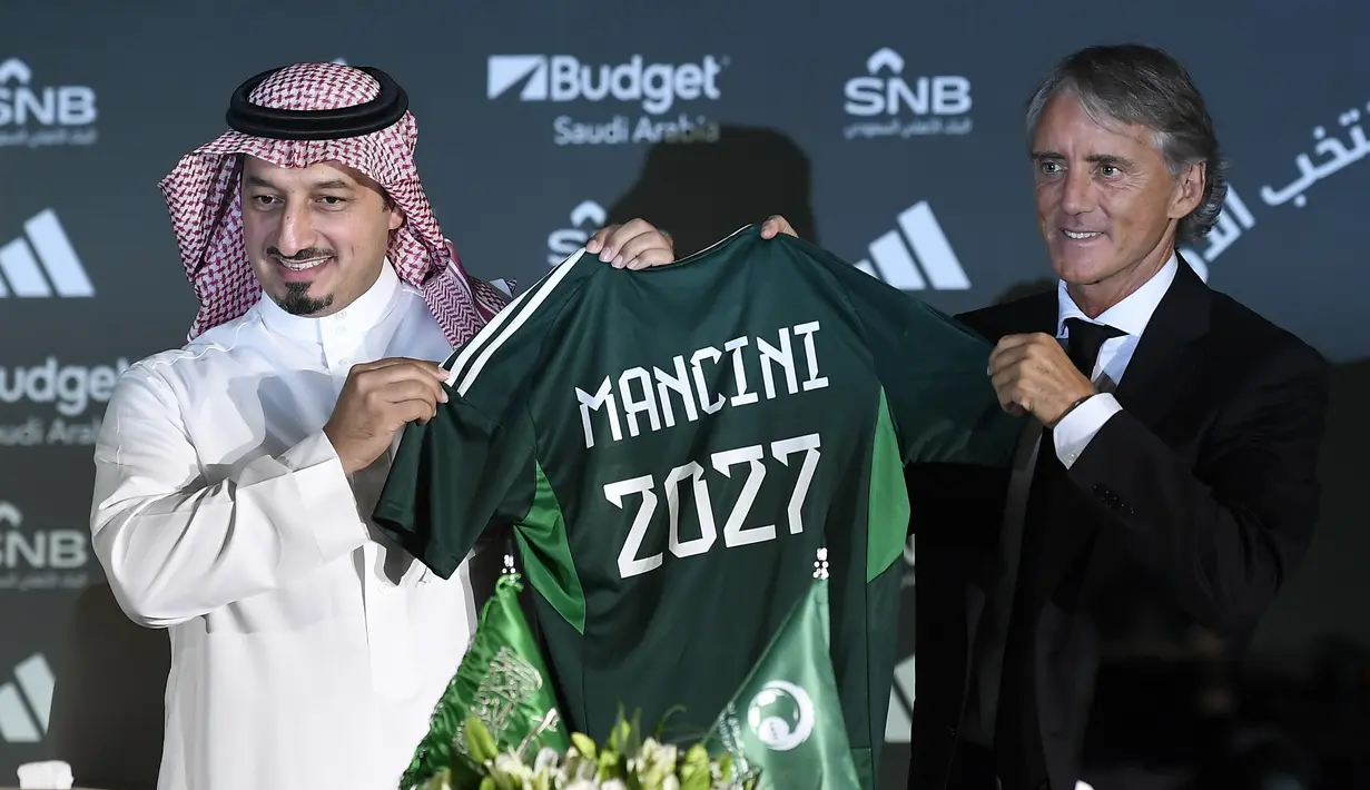 <p>Presiden Federasi Sepak Bola Arab Saudi, Yasser Al Misehal (kiri), mengenalkan pelatih anyar Timnas Arab Saudi, Roberto Mancini (kanan), dalam sesi konferensi pers yang berlangsung di Riyadh, Arab Saudi, Senin (28/8/2023). (AP Photo)</p>