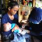 Petugas medis Puskesmas Cisimeut Bidan Pite memberikan imunisasi DPT 1 kepada bayi 3 bulan Posyandu keliling di Kampung Baduy Luar Gazebo, Kanekes, Banten, (Rabu (27/01/2021). Setiap bulannya Bidan Pite berkeliling Baduy Luar sepanjang 14 km pulang pergi berjalan kaki. (merdeka.com/Arie Basuki)