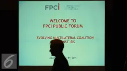 Peserta diskusi melintasi di depan proyektor diskusi FPCI Public Forum di Hotel Borobudur Jakarta, Selasa (8/12/2015). Diskusi membahas Pergeseran Koalisi Internasional Melawan ISIS dihadiri sejumlah duta besar. (Liputan6.com/Helmi Fithriansyah)