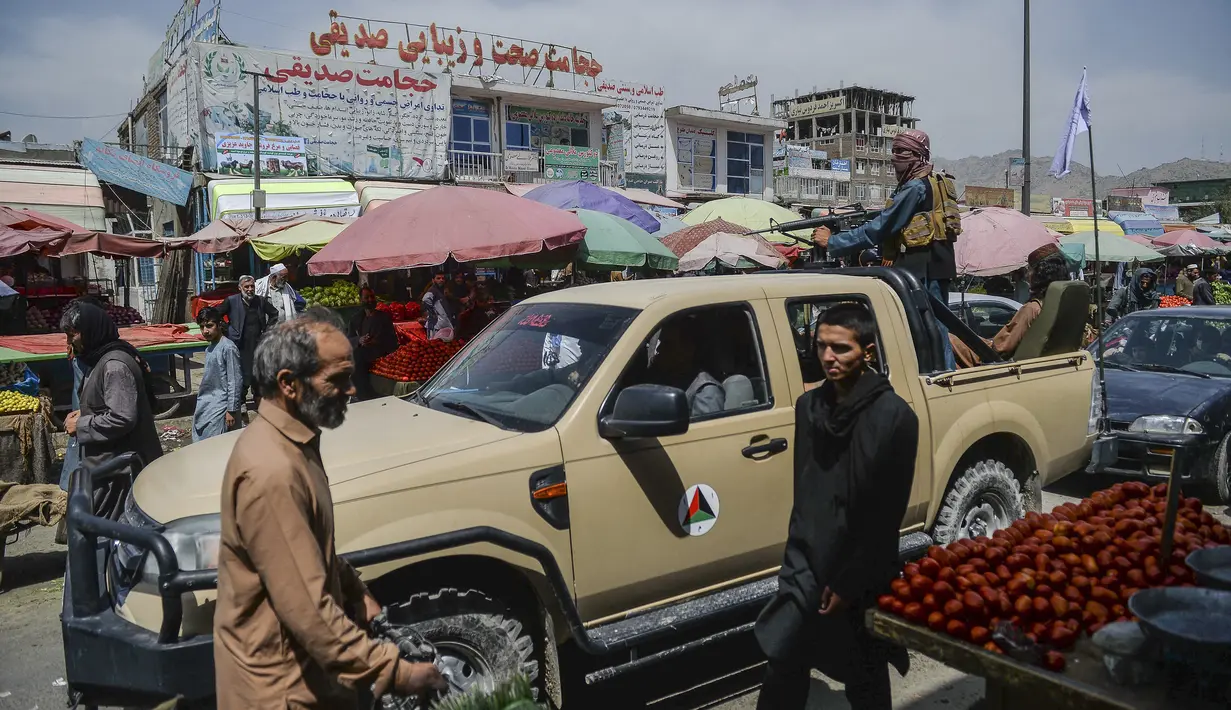 Pejuang Taliban dengan truk pick-up bergerak di sekitar area pasar setelah Taliban menguasai ibukota menyusul runtuhnya pemerintah Afghanistan di daerah Kote Sangi di Kabul (17/8/2021). (AFP/Hoshang Hashimi)