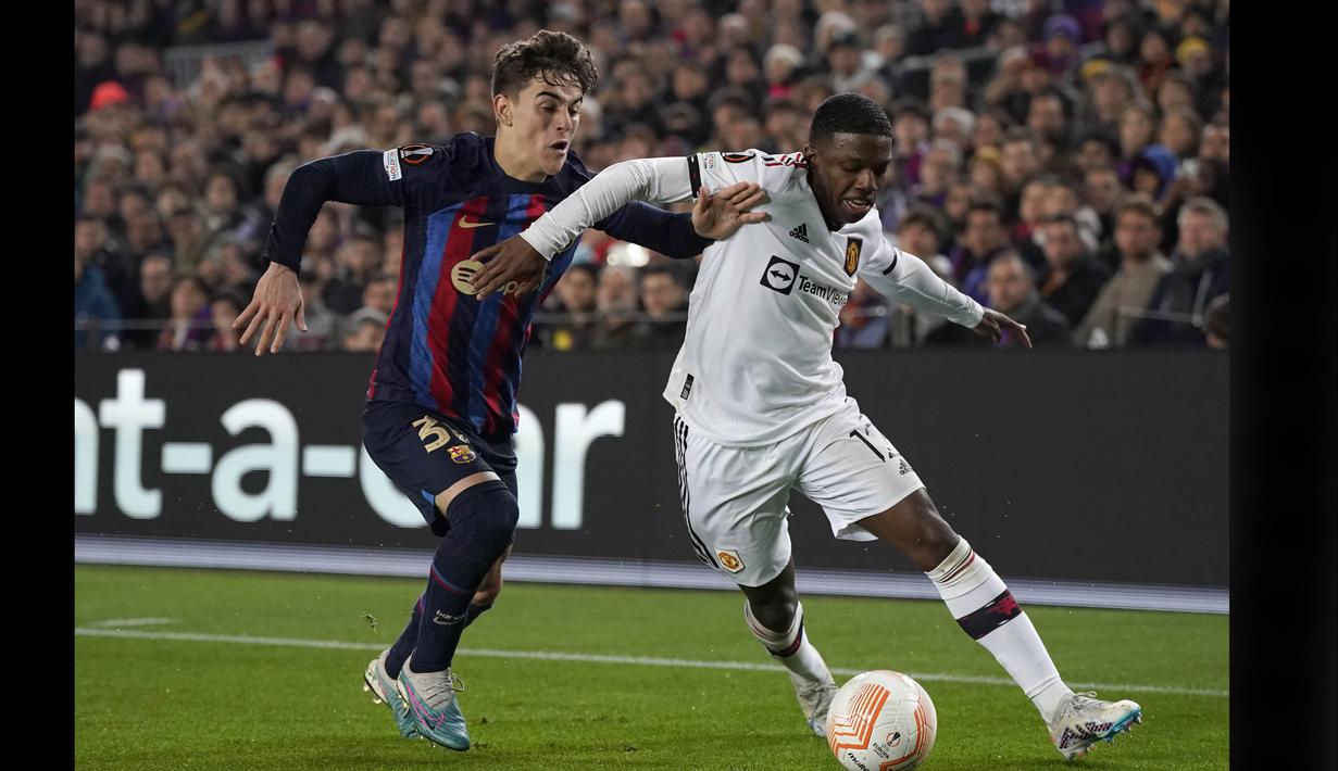 Pemain Barcelona, Gavi (kiri) berusaha merebut bola dari pemain Manchester United, Tyrell Malacia dalam pertandingan leg pertama play-off fase knockout Liga Europa 2022/2023 yang digelar di Stadion Spotify Camp Nou, Jumat (17/2/2023) dini hari WIB. (AFP/Josep Lago)