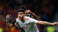 Pemain timnas Spanyol, Marco Asensio berebut bola dengan pemain timnas Argentina, Fabricio Bustos dalam laga uji coba di Wanda Metropolitano, Madrid, Rabu (28/3). Argentina yang tak diperkuat Lionel Messi tumbang 1-6. (AP/Francisco Seco)