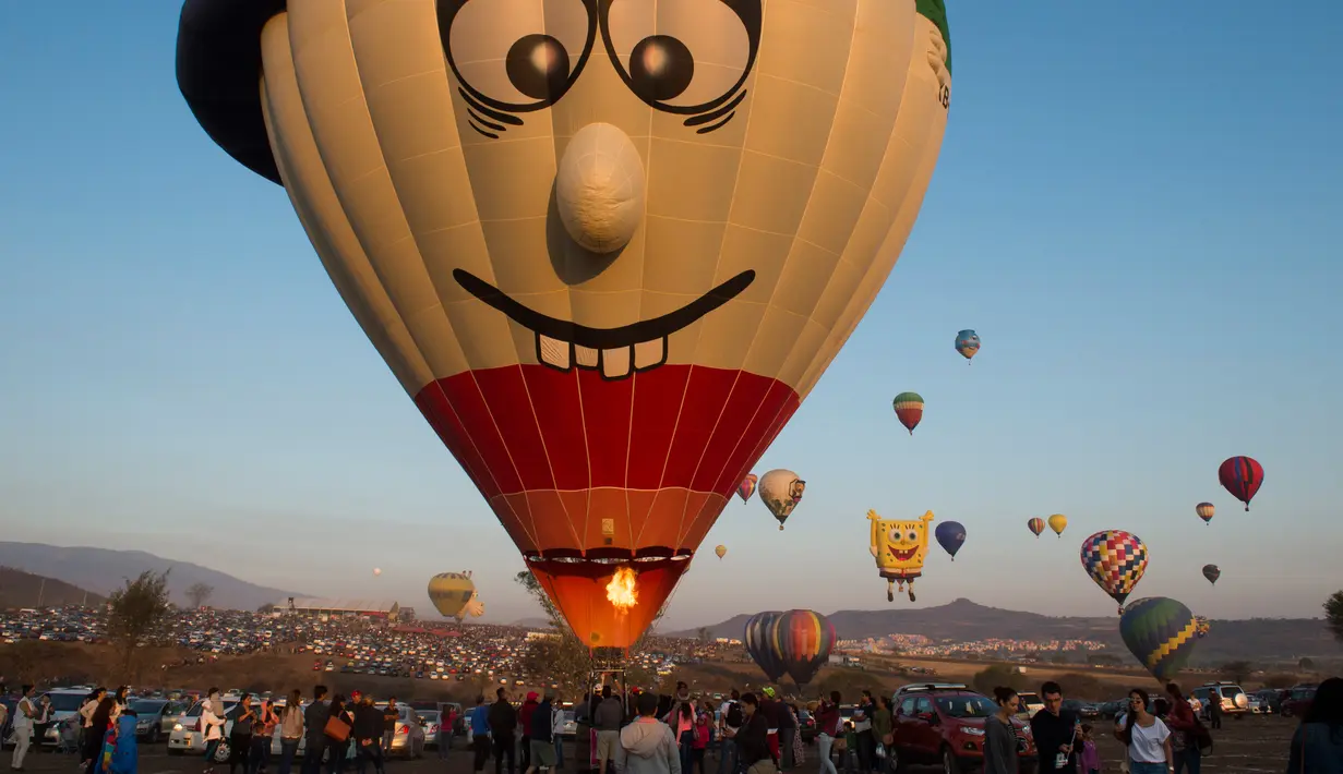 Salah satu peserta yang bersiap menerbangkan balon udaranya saat Festival balon udara di Cajititlan, Meksiko, Minggu (7/5).  Festival balon udara ini menjadi tontonan menarik bagi warga sekitar dan wisatawan. (AFP PHOTO / Hector Guerrero)