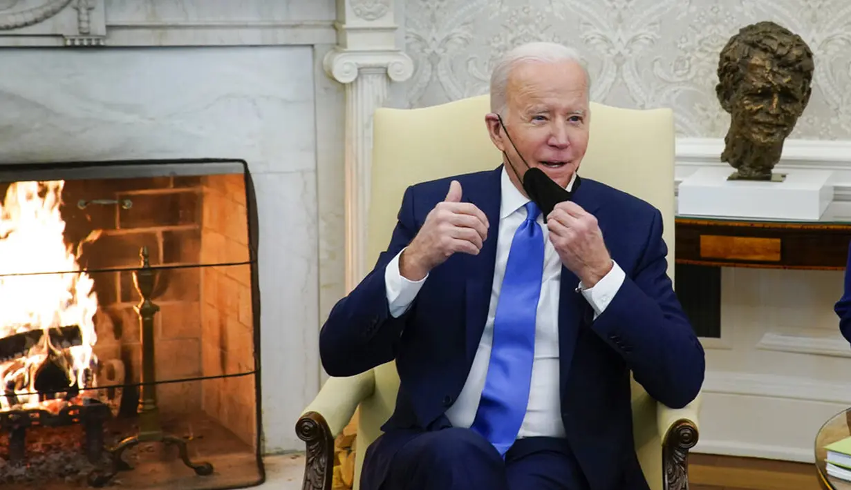 Presiden AS Joe Biden melepas masker saat berbicara pada pertemuan dengan Kanselir Jerman Olaf Scholz di Kantor Oval Gedung Putih, Washington, AS, 7 Februari 2022. AS dan Jerman menjalin kerja sama untuk mencegah agresi Rusia di Eropa serta tantangan yang ditimbulkan China. (AP Photo/Alex Brandon)