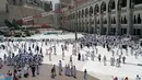 Ribuan umat muslim yang sedang menunaikan ibadah haji berjalan melintasi crane yang roboh di Masjidil  Haram, Mekah,  Arab Saudi (9/12/2015). Sebanyak 107 calon jemaah haji meninggal dunia akibat crane jatuh karena cuaca buruk. (REUTERS/Mohamed Al Hwaity)